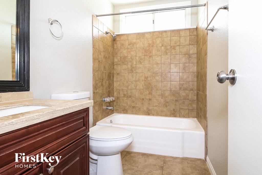 a bathroom with a toilet and a tub and a sink