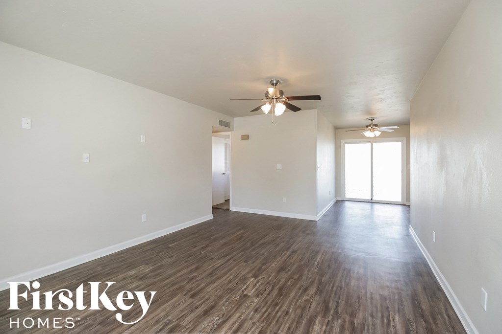 the living room of an empty house with a ceiling fan
