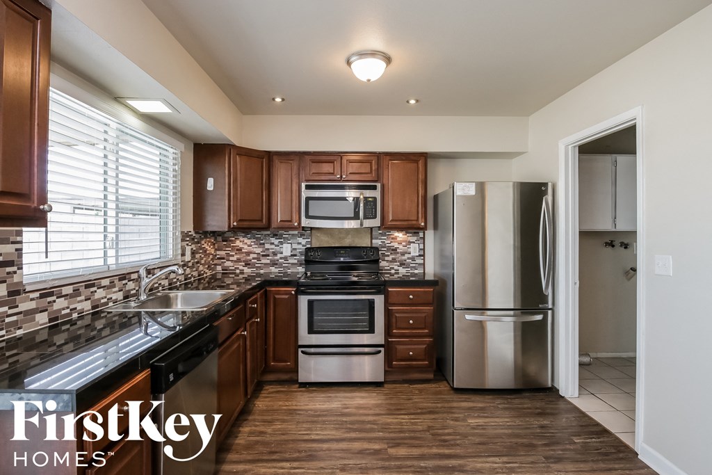 a kitchen with wooden cabinets and stainless steel appliances