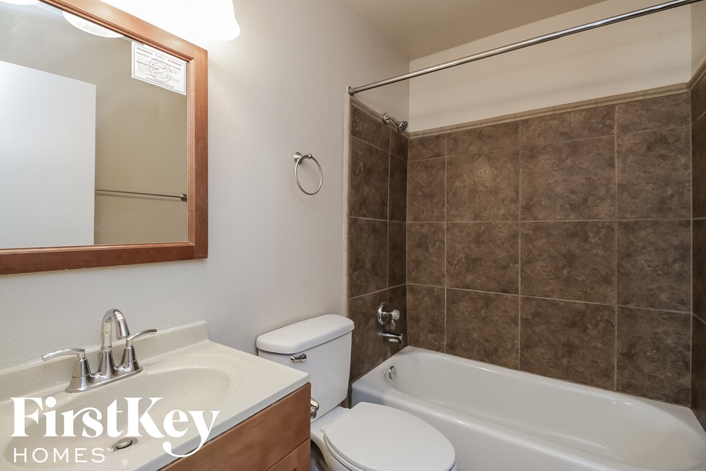 a bathroom with a toilet sink and a tub and a mirror