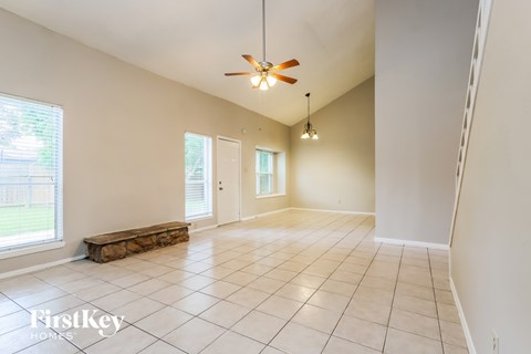 A spacious room with a ceiling fan and tile flooring.