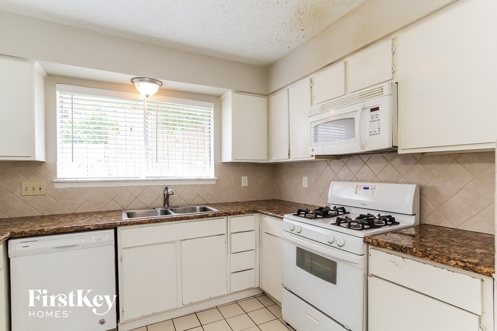 a kitchen with white appliances and white cabinets
