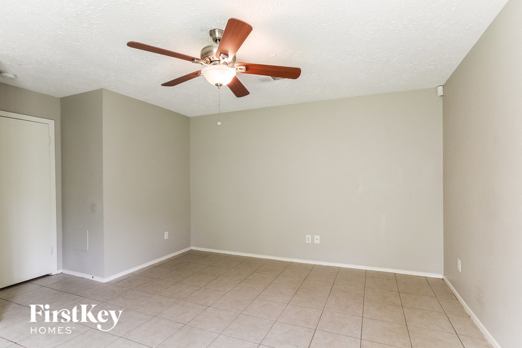 a living room with a ceiling fan and a tiled floor