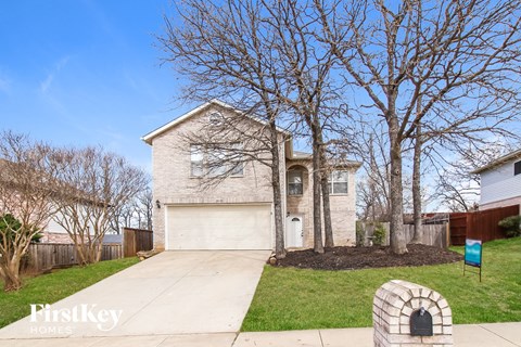 A house with a garage and a driveway in front of it.