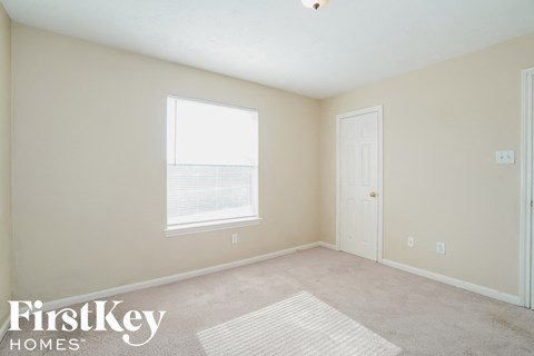 a bedroom with a carpeted floor and a window