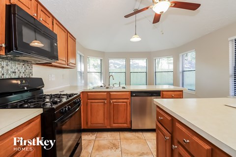 A kitchen with wooden cabinets and a black stove top oven.