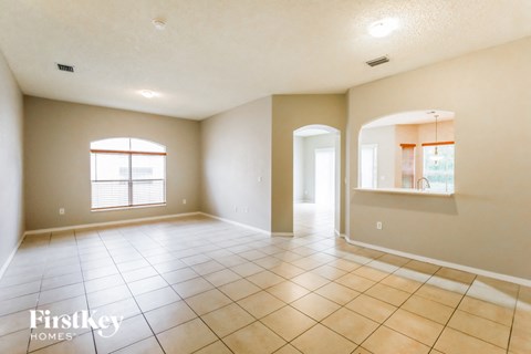 an empty living room with tiled floors and a window