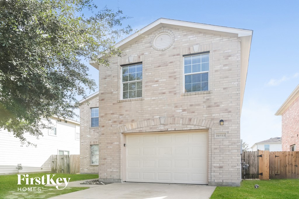 a white brick house with a white garage door