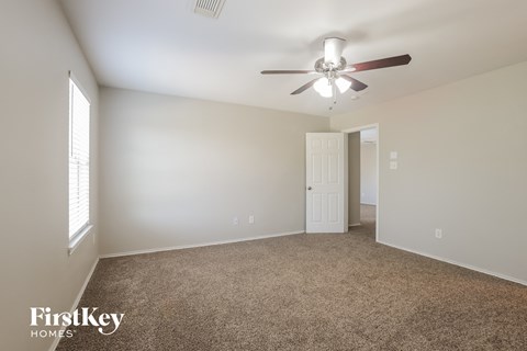 a living room with carpet and a ceiling fan