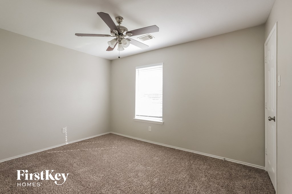 a empty room with a ceiling fan and a window