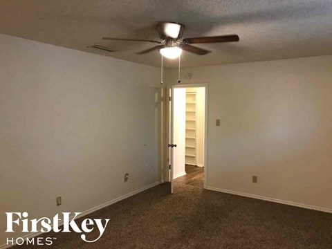 a bedroom with a ceiling fan and a door to a closet