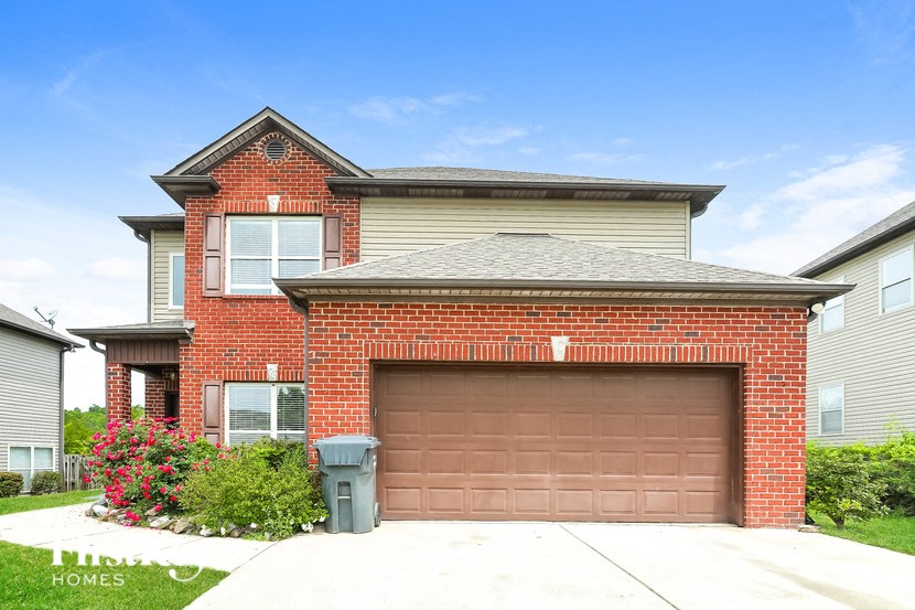 a brick house with a brown garage door