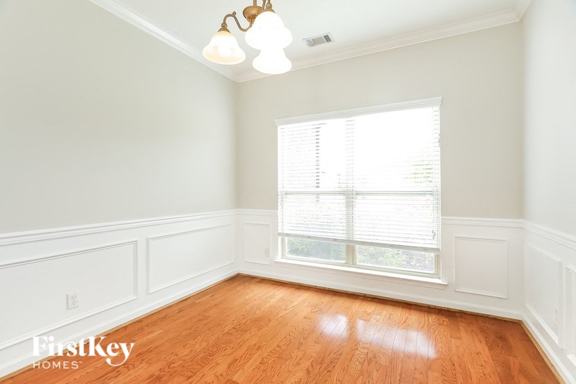 an empty room with a window and wooden floors
