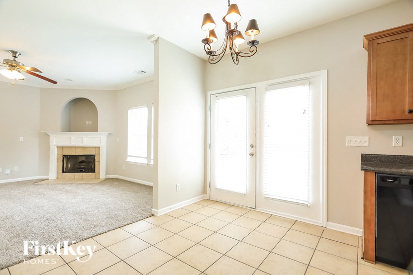 a living room with a fireplace and a door to a kitchen