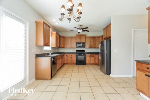 a large kitchen with wooden cabinets and black appliances