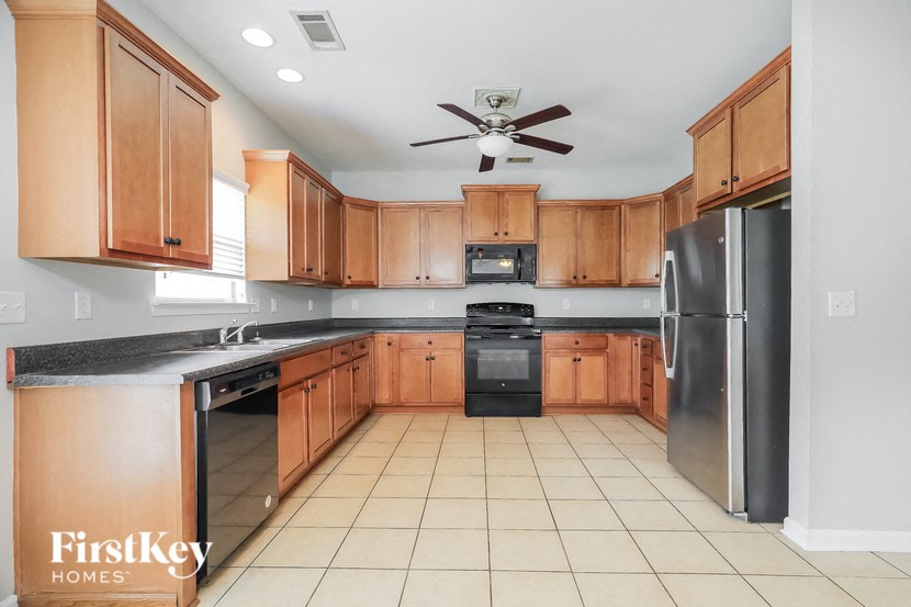 a large kitchen with wooden cabinets and stainless steel appliances