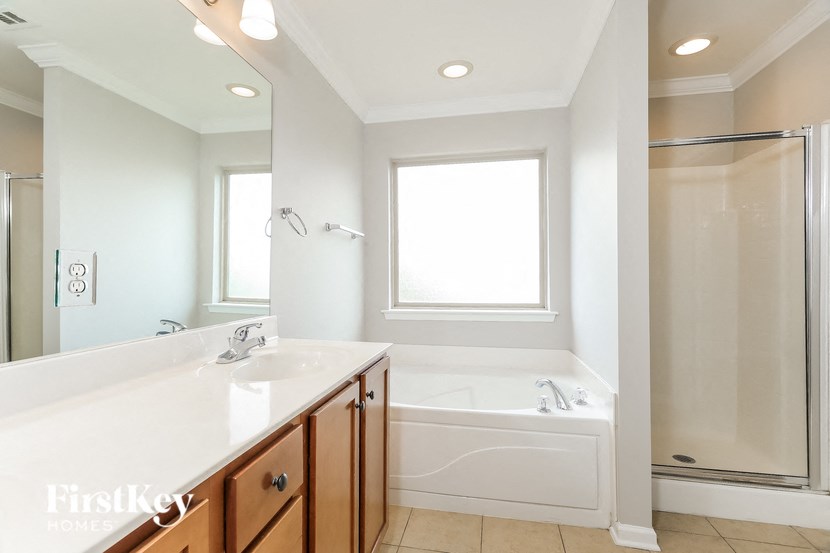 a bathroom with a tub and a sink and a mirror