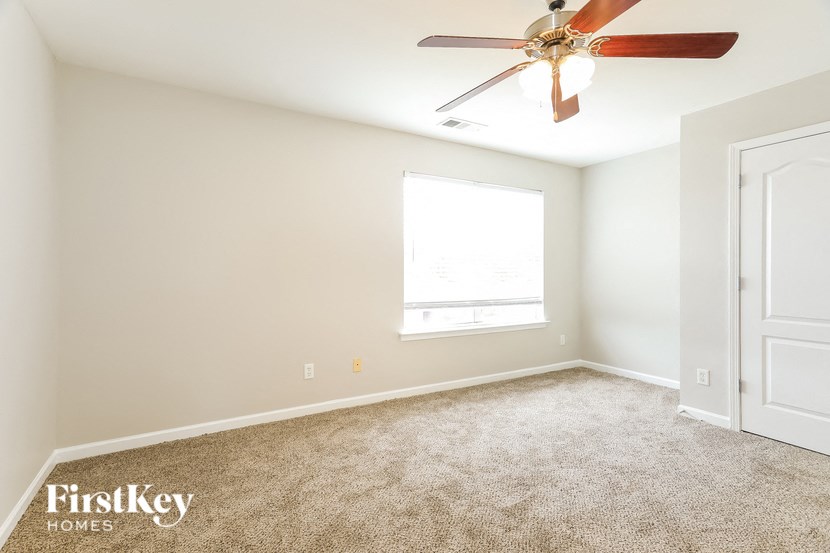 a white room with a ceiling fan and a window