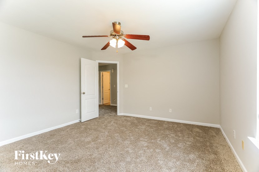 a bedroom with a ceiling fan and a carpeted floor