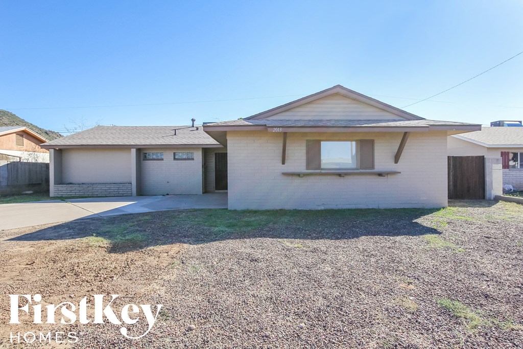 a small white house with a lawn and a driveway
