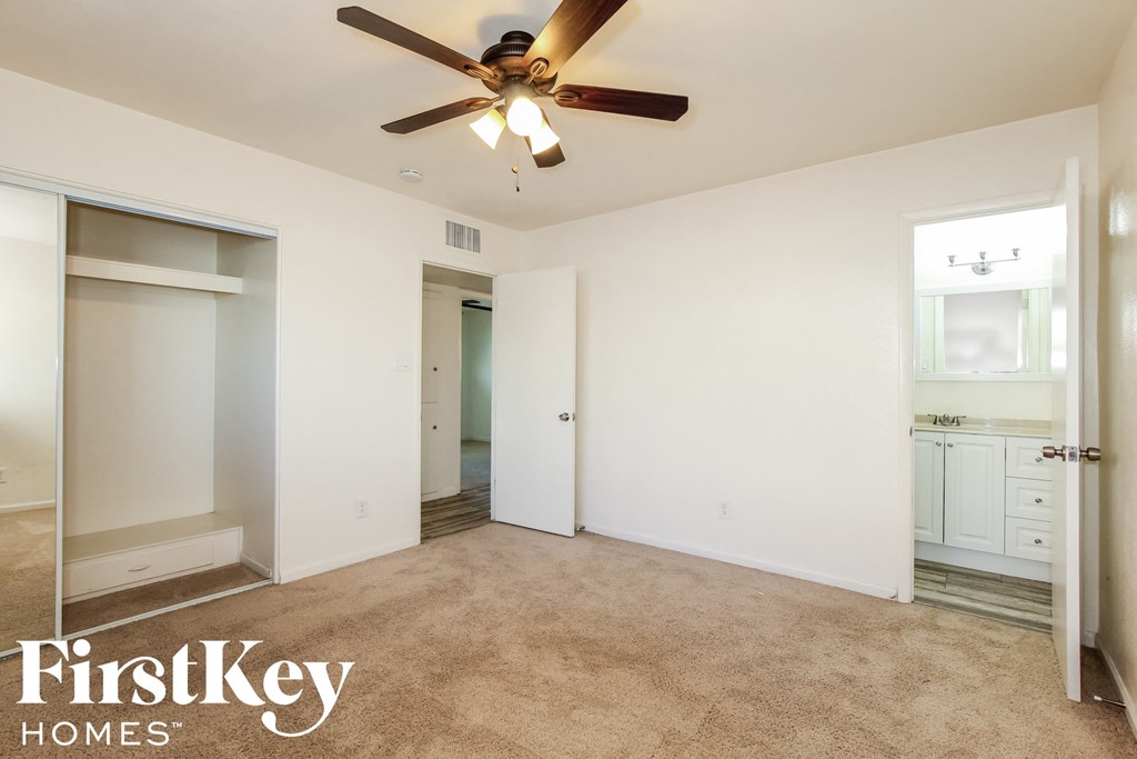 a bedroom with a ceiling fan and a closet
