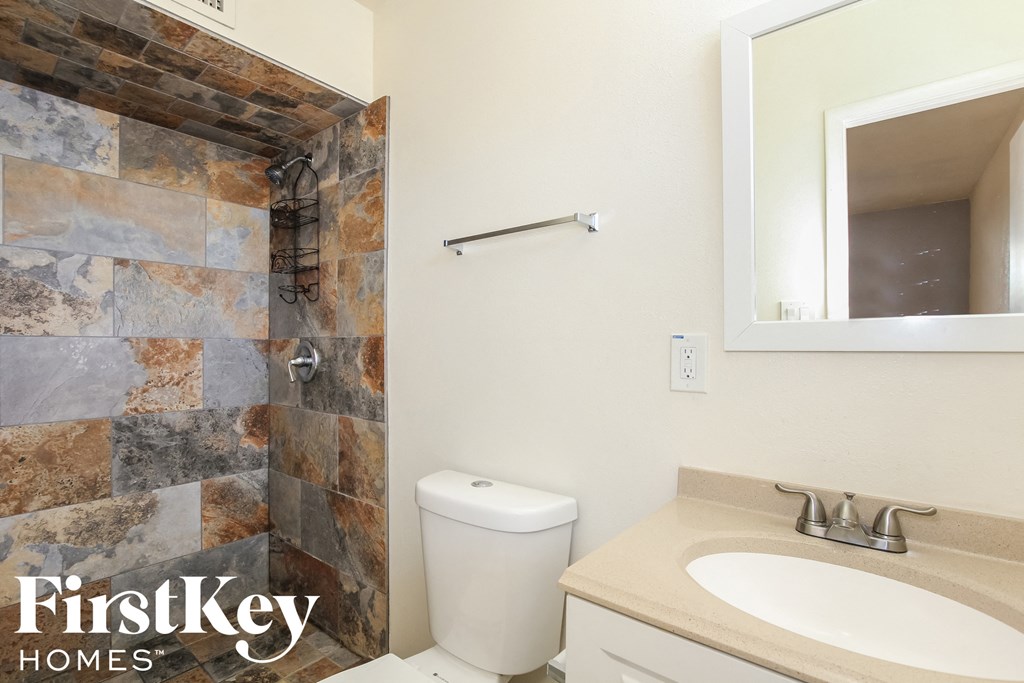 a bathroom with a toilet and a sink and a mirror
