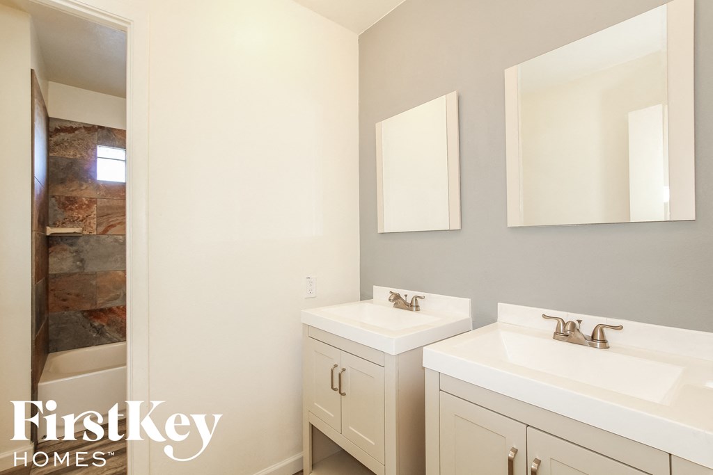 a bathroom with two sinks and a mirror and a shower