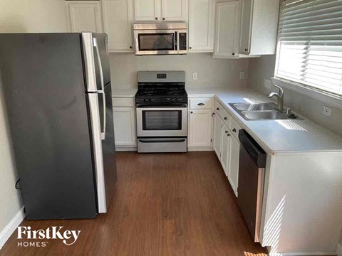 a small kitchen with white cabinets and stainless steel appliances