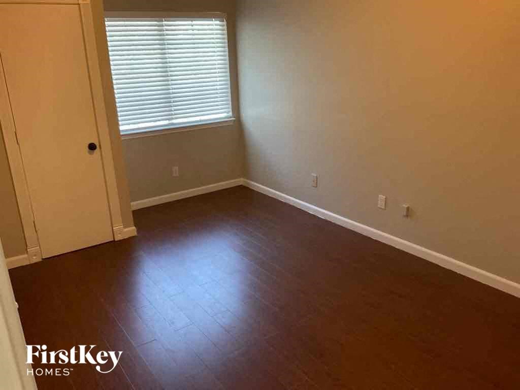 an empty living room with wooden floors and a window