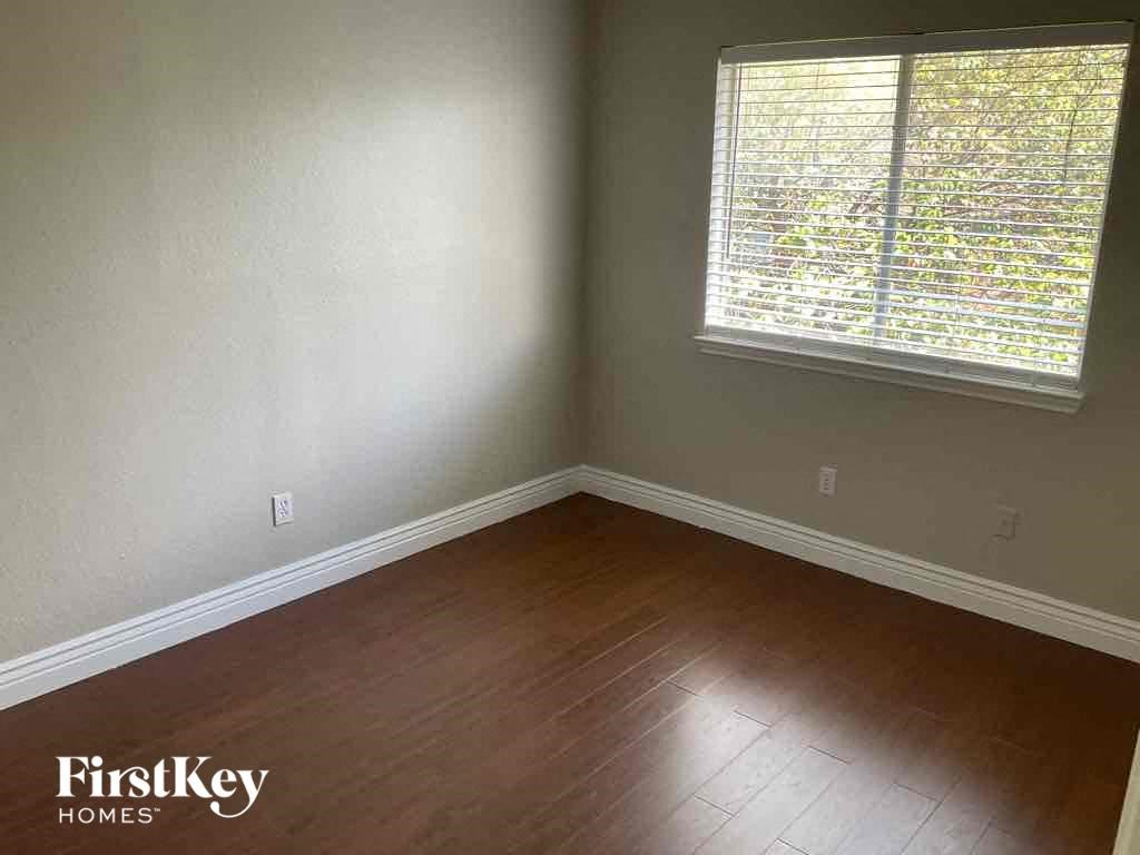 an empty room with wooden floors and a window