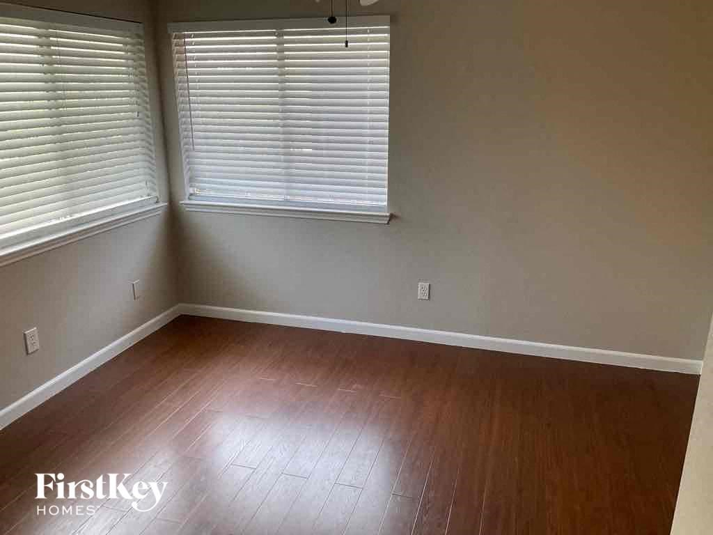 an empty living room with wood floors and a window