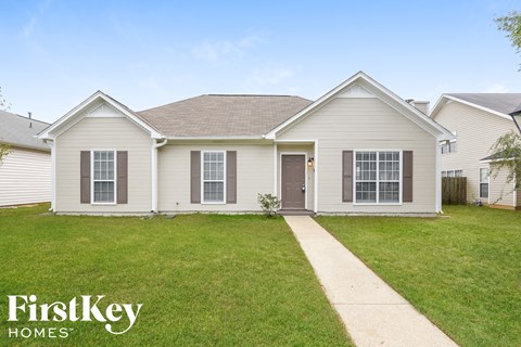 a white house with a lawn and a sidewalk