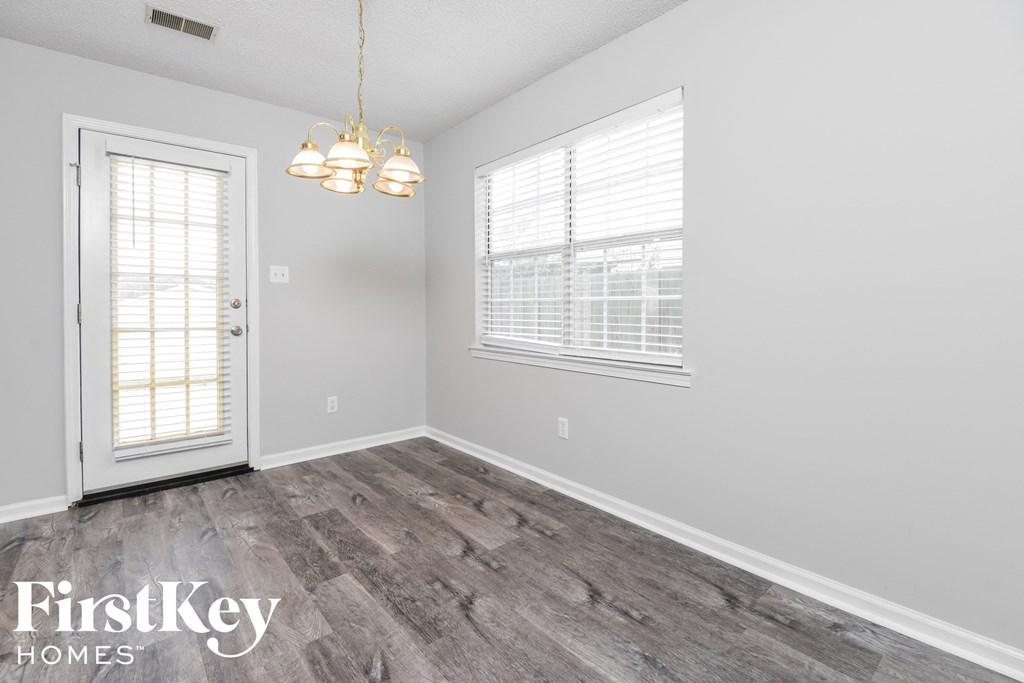 a bedroom with wood flooring and white walls and a door