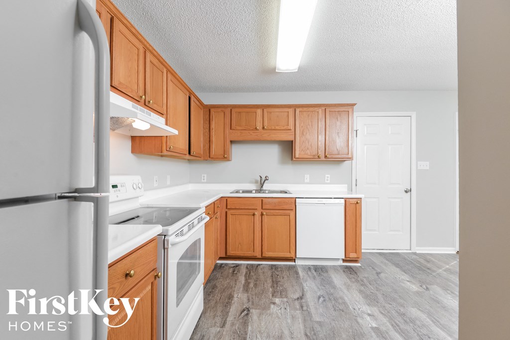 a kitchen with wood cabinets and white appliances and a refrigerator