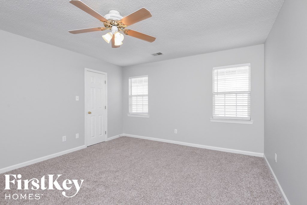 a bedroom with a ceiling fan and a white door