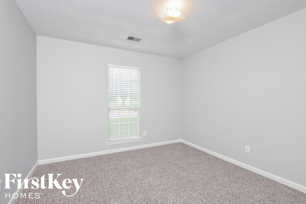 a bedroom with a carpeted floor and a window