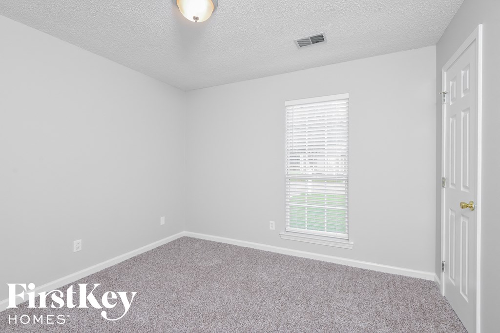 a bedroom with a carpeted floor and a window