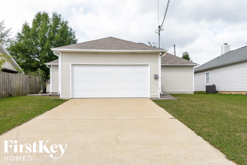 a white house with a driveway and a white garage door