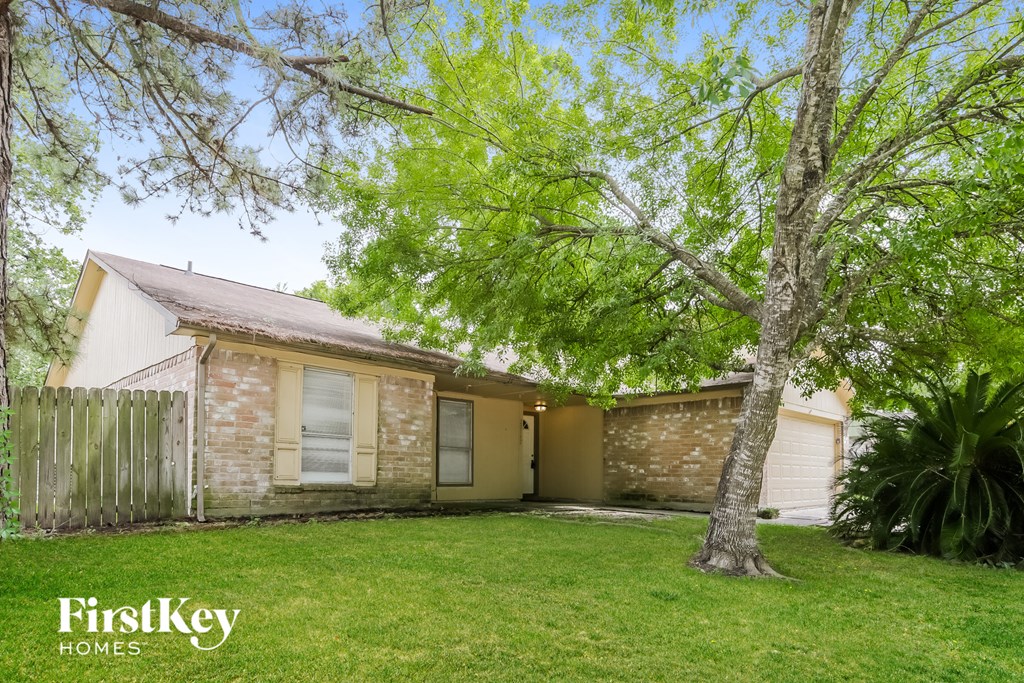 a small brick house with a yard and a tree