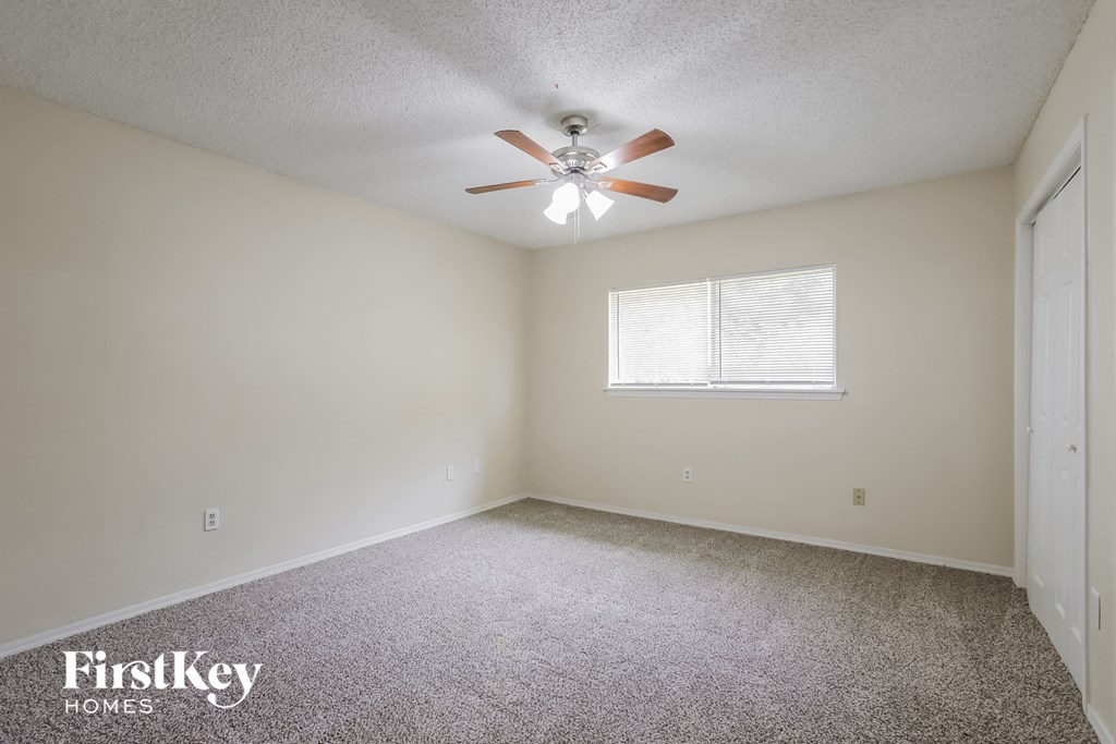 a bedroom with carpet and a ceiling fan