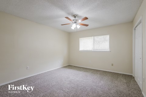 a bedroom with carpet and a ceiling fan