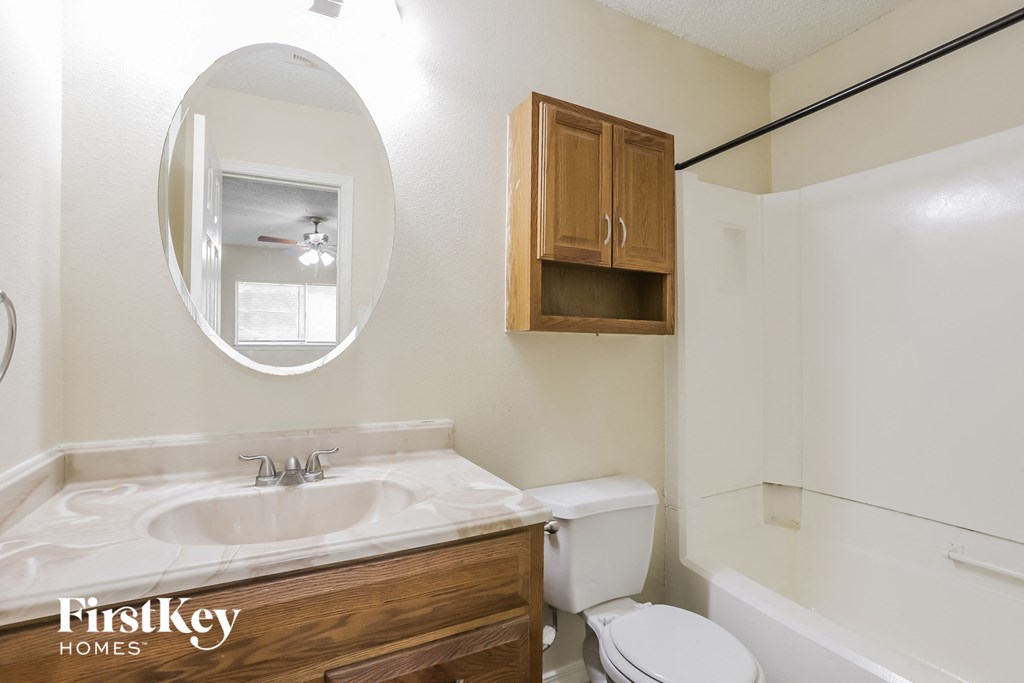 a bathroom with a toilet and a sink and a mirror
