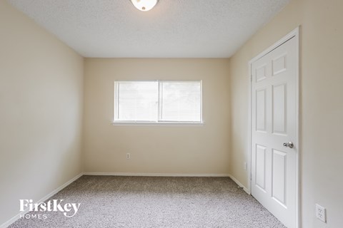 a bedroom with a window and a white door