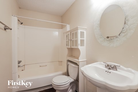 a white bathroom with a sink toilet and bath tub