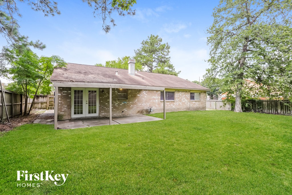 a backyard with a brick house and a green lawn