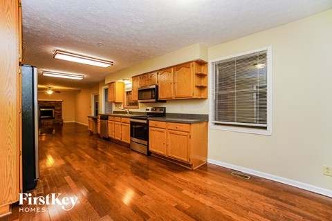 A kitchen with wooden cabinets and a black countertop.