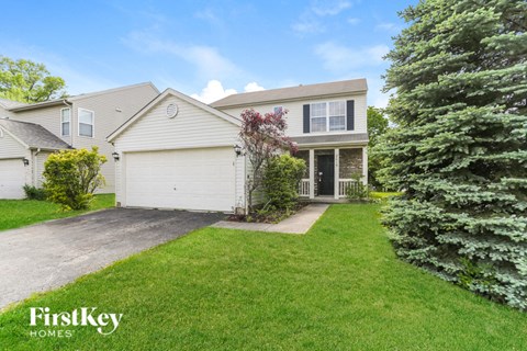 A house with a white garage door is for sale by FirstKey Homes.