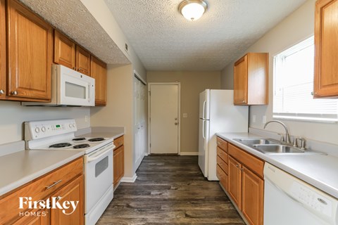 A kitchen with wooden cabinets and white appliances.