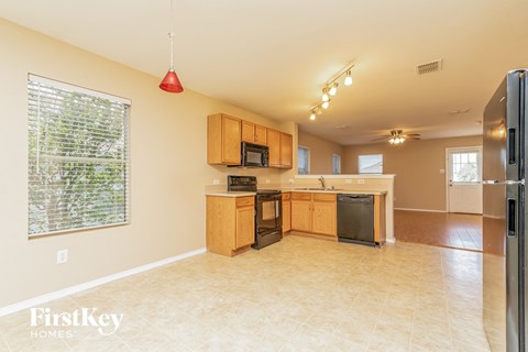 a kitchen with wood cabinets and black appliances and a large window