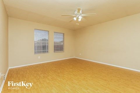a spacious living room with wood floors and a ceiling fan